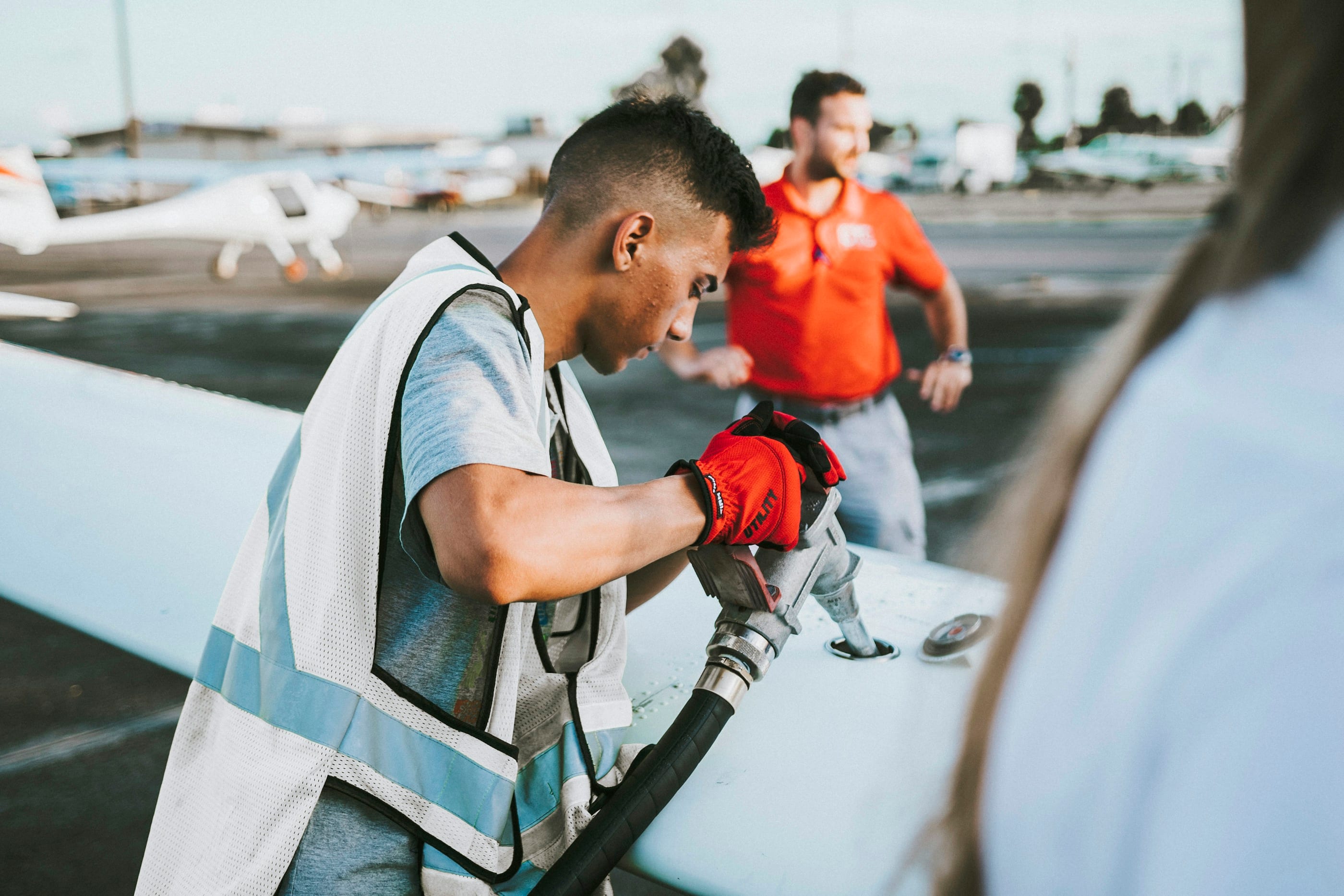 Personal de plataforma reabasteciendo una aeronave